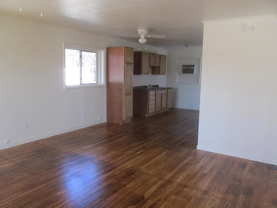 LEFT LIVING AREA LOOKING TOWARD KITCHEN CABINETS BATHROOM ON THE LEFT OF CABINETS