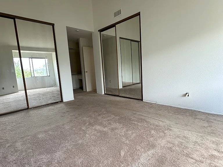 Primary Bedroom Double Mirrored Closets and Vaulted Ceilings