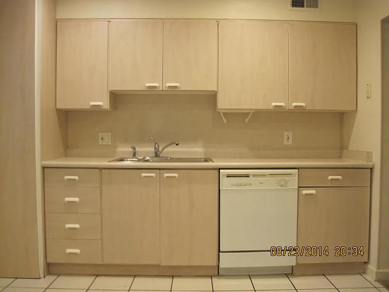 Sink & Dishwasher with 40 gallon water heater behind floor to ceiling cabinet on the left.