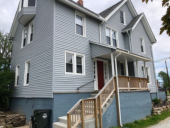 Side view and entrance to downstairs unit and basement with washer/dryer hookup