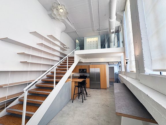 entry view of 17' soaring ceilings, mezzanine and kitchen