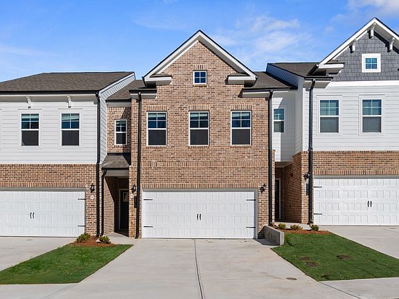 New construction townhome with brick front and two car garage in Riverdale, GA.