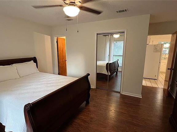 Bedroom featuring tile flooring, white fridge, a closet, and ceiling fan