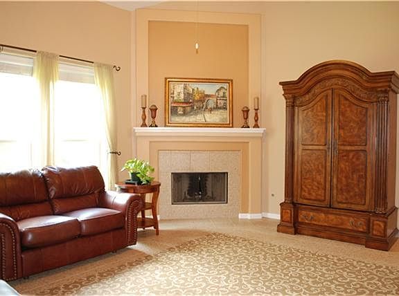 Large tiled living room with a fireplace that has gas connections or can be wood burning.