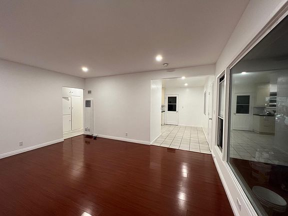 Living room looking towards entryway and kitchen on the right, beds/bath are through hallway on the left