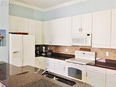 Full view of kitchen and island with granite countertops.