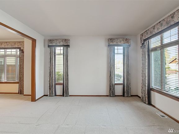 The formal living room is light and bright with the large picture window overlooking the front yard. In addition to curtains, all of the rooms in this house feature either 2" wood blinds or shades that can be raised from the bottom or dropped down from the top to reveal a sheer panel to allow for additional light and privacy.