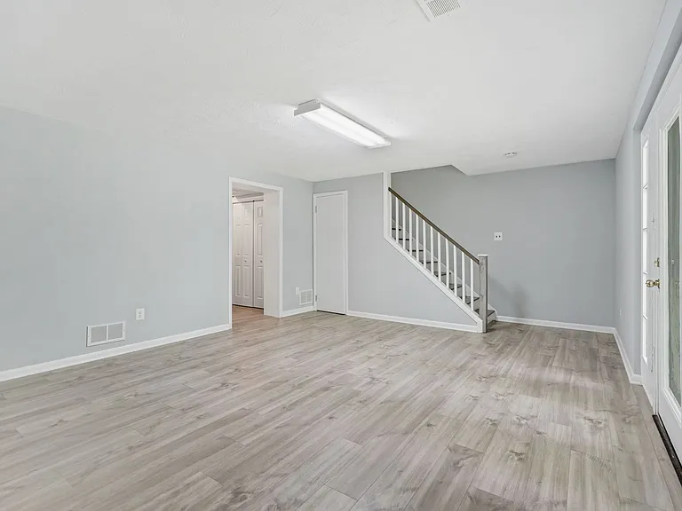 bottom floor - possible in-law suite - living room / den - stairs to middle floor - doorway to bedroom