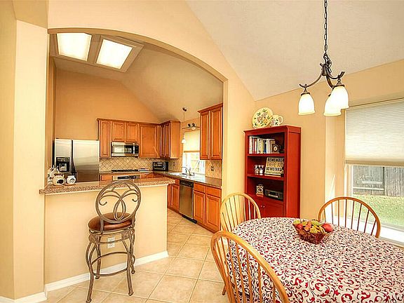 Breakfast room with updated light fixture, surrounded by 2 large windows.