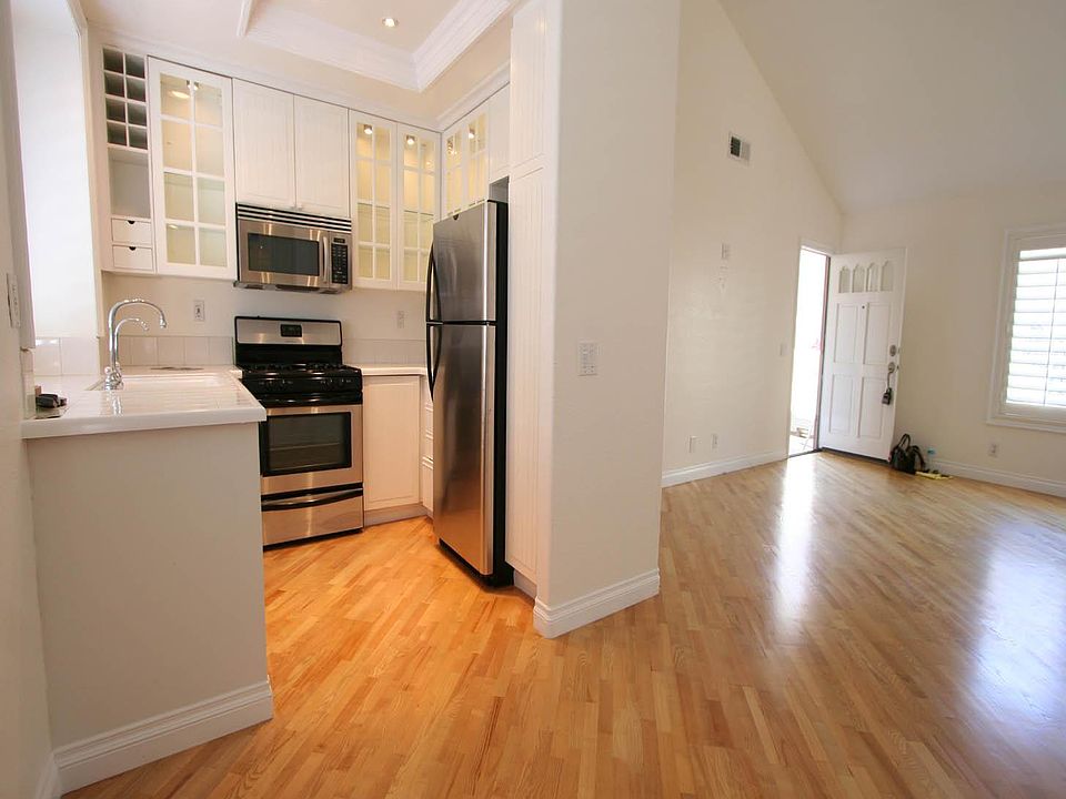 Looking from the Dining area to the kitchen and to the open living area and front door.