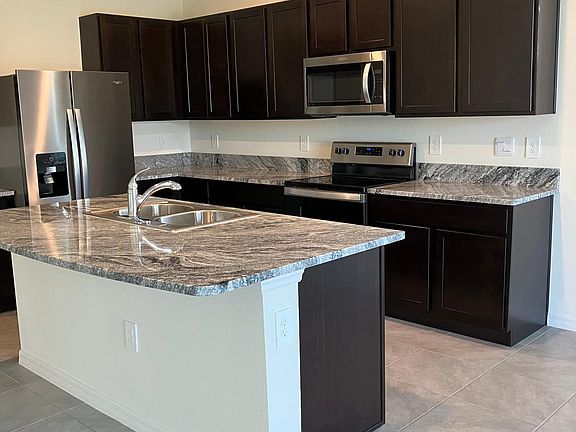Nice and functional kitchen with stainless steel appliances and granite countertops.
