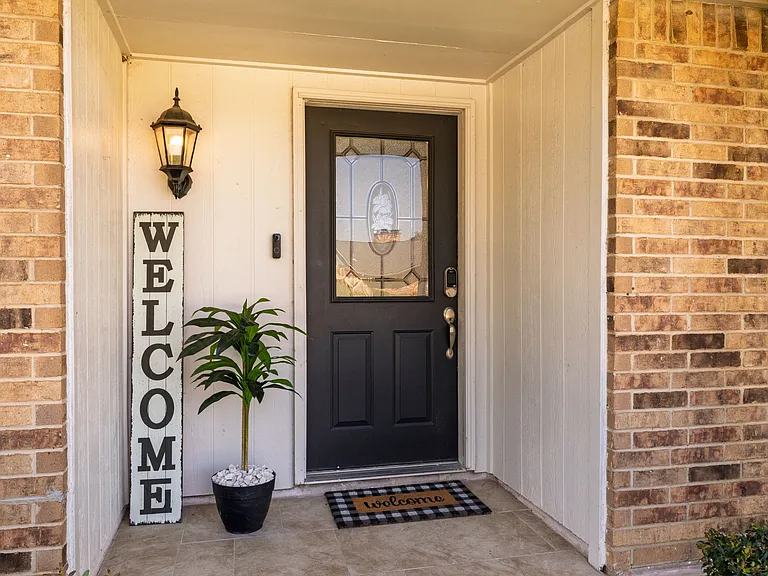 The front entry of this stunning home is welcoming with cute decor offering a warm and inviting first impression.