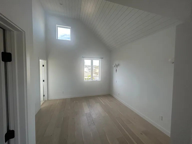 Bedroom with oversized windows high ceilings and walk-in closet private bathroom