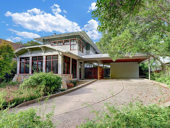 Custom home perched on a hill. Front porch featured at the front of the house.