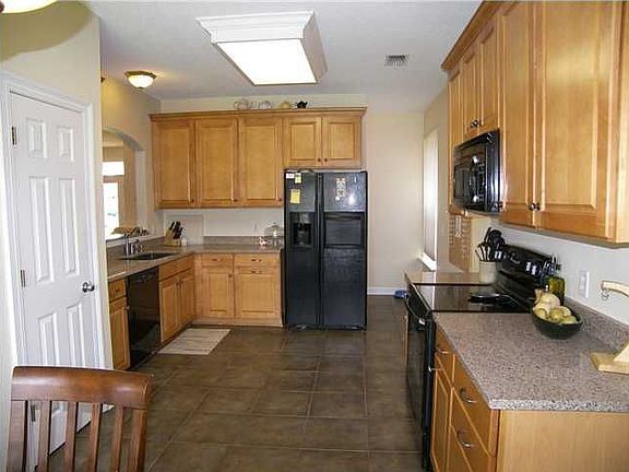 Modern kitchen includes maple cabinets and silestone countertops