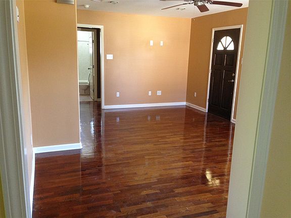 Spacious living room with refinished hardwood floors and gre