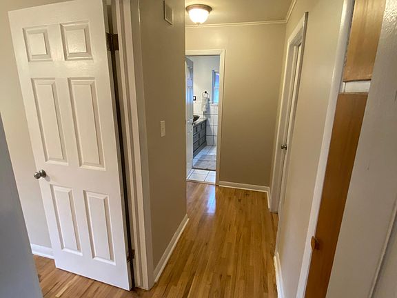 hallway with first bedroom to the left storage closet to the right, master bedroom further down on the right. bathroom at end of hall and 3rd bedroom to the far left