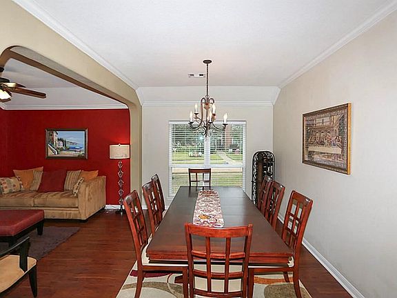 Formal dining room flows with the formal living room. Crown molding in this bright room.