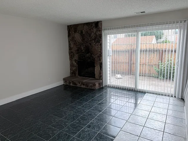 great room with fireplace and patio