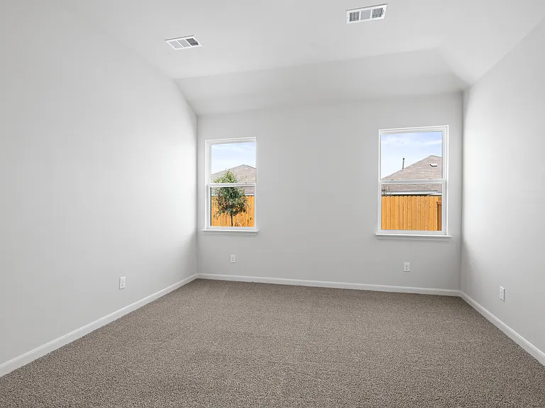The master bedroom is spacious and has two large windows.