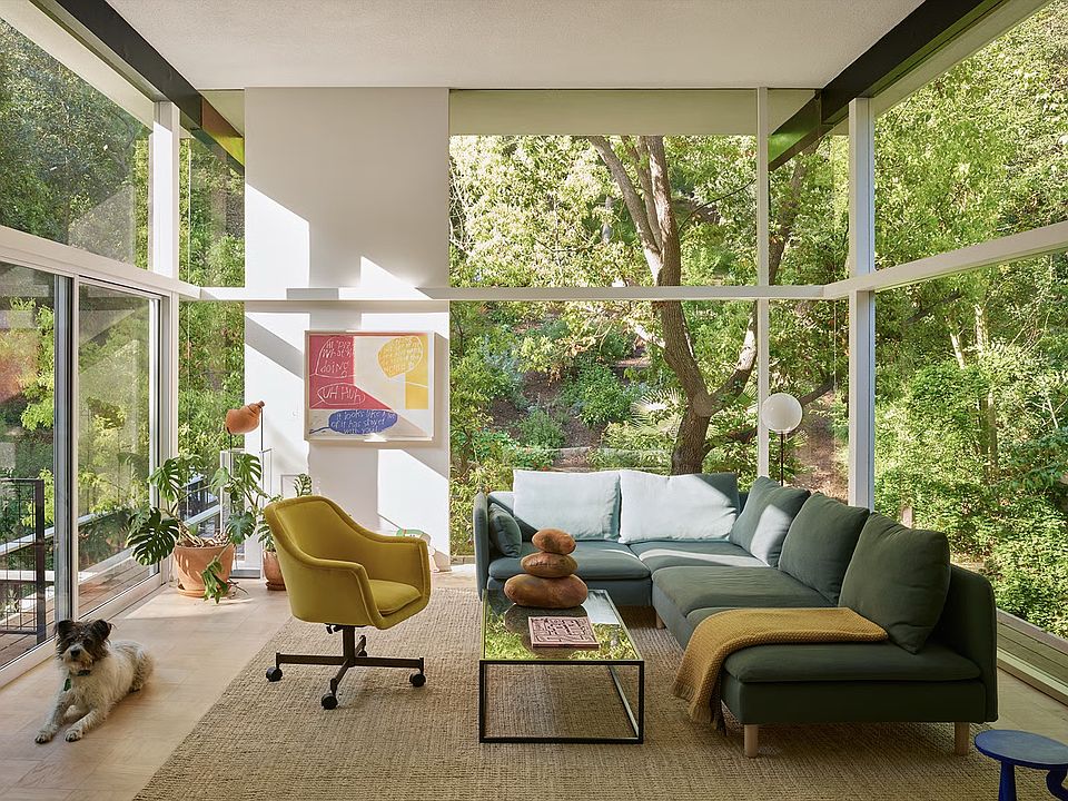 Living room, surrounded by trees and cantilevered over creek