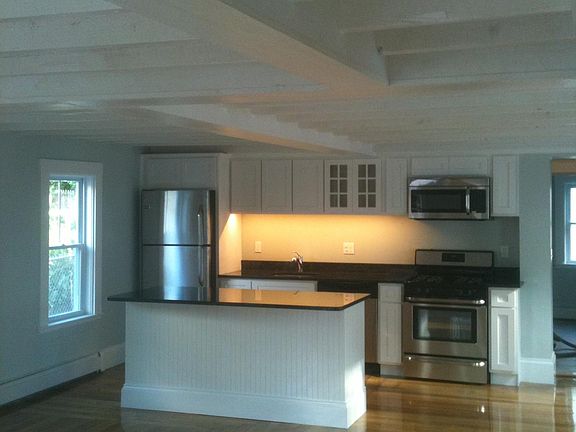 First floor open concept--living and dining is large with exposed beams above.