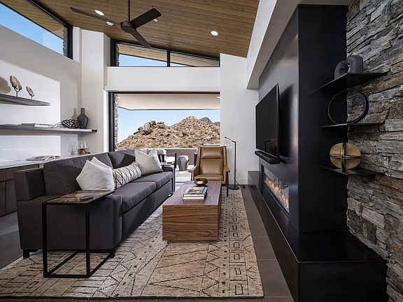 Open great room with fireplace, vaulted ceilings, and multi-slide patio door