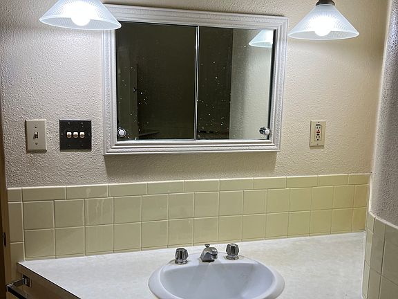 Yellow retro style bathroom with yellow tile throughout. With a full size tub/shower. It also has a really large linen/storage closet.