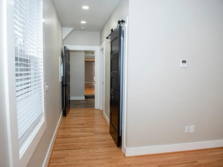 Hallway from primary to kitchen (barn door is closet access)