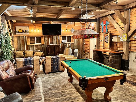A game room featuring a pool table, darts, lots of comfortable seating and a smart tv perfect for entertainment.