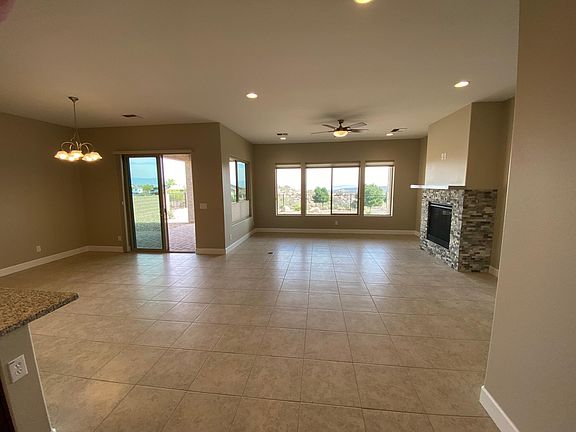 Great room with rock fireplace and mantle. Floor plug for powered recliners or sofa. Exits onto large covered patio.