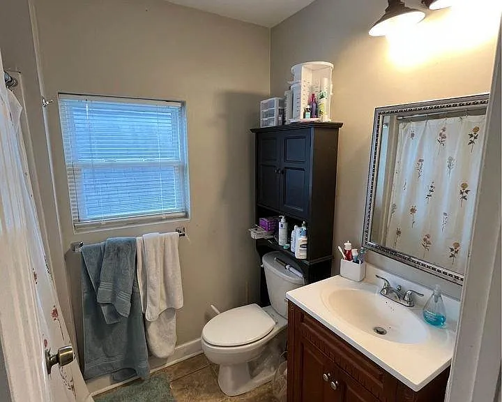 Full bathroom with vanity, tub/shower, and natural light from the window.
