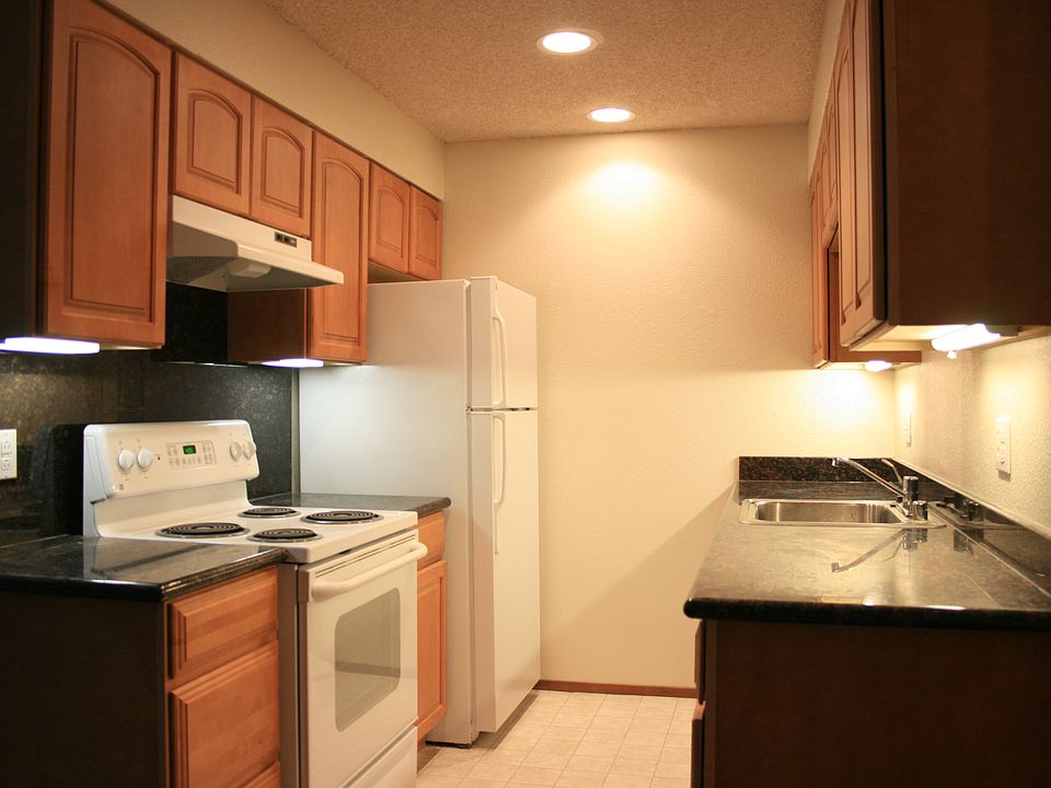 Galley style kitchen with all electric appliances, granite countertops, undercabinet lighting, and soft close cabinetry.