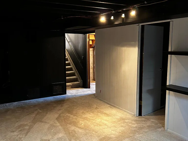 stairs leading to basement. Basement bedroom and storage space