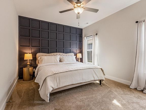 Primary bedroom with king size bed, dresser, bed linens, wooden hangers, attached bathroom.