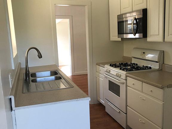 Galley kitchen window facing backyard over sink