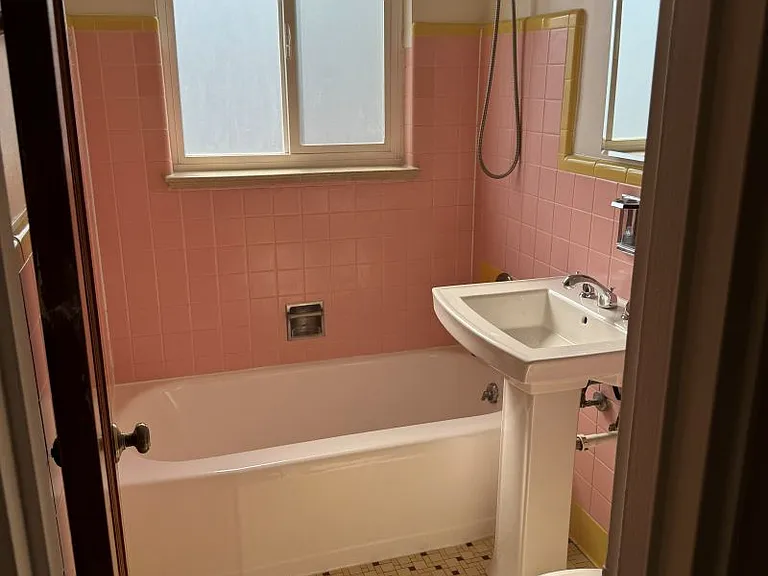 Well lit clean bathroom with curved shower rod for more elbow room.