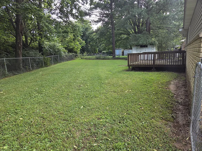 Fenced in back yard with deck