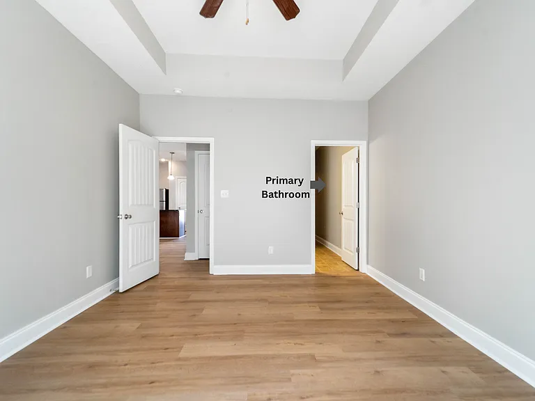 Primary Bedroom (Arrow points to the en-suite bath and spacious walk-in closet off the primary bedroom)