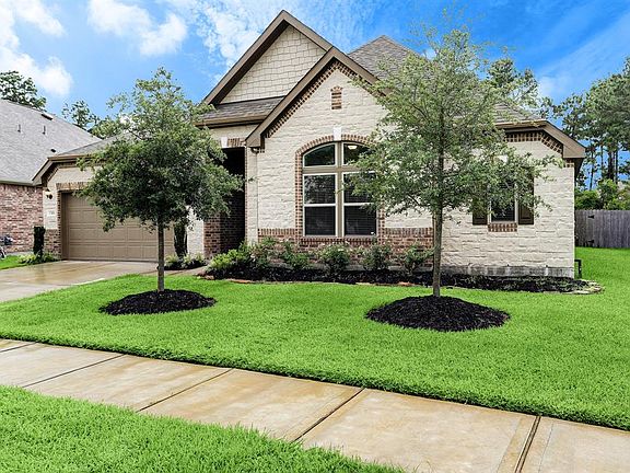 Stunning front elevation of this home with great curb appeal, lush landscaping, stone and brick detail, and front sidewalk. Welcome home!