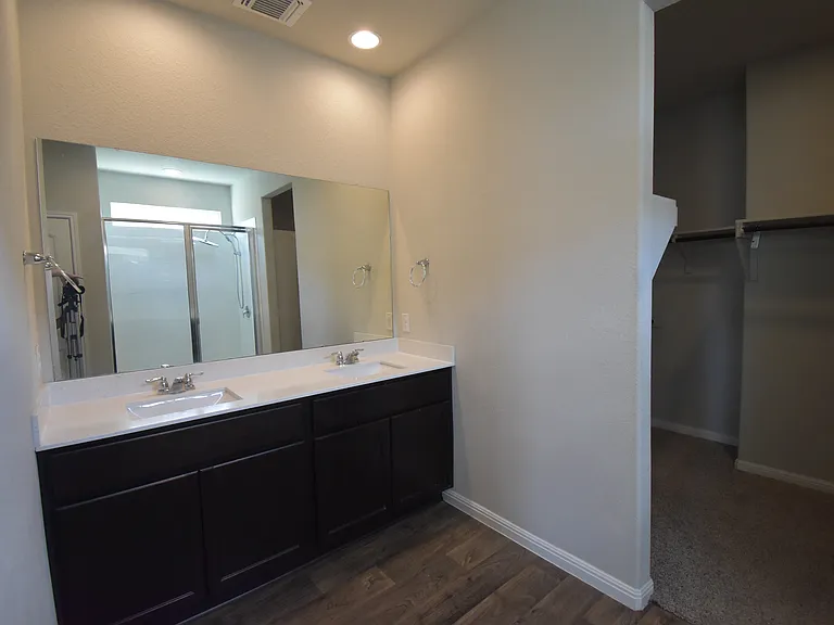 Primary bathroom features double vanity and walk-in closet