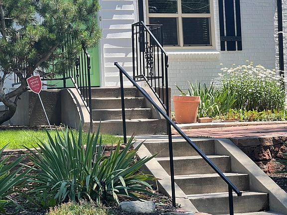 beautiful front yard with terraced moss rock garden, automatic sprinkler system, and lots of flowers
