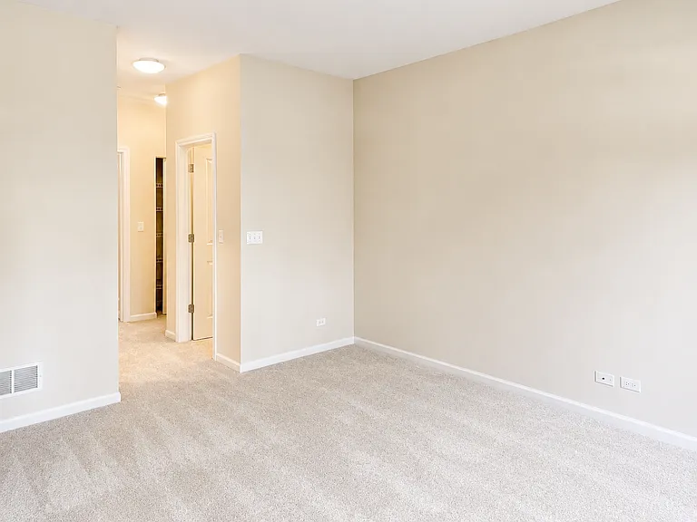 First-floor master suite, viewed from inside the master bedroom, looking down the aisle leading to the master bathroom, with walk-in closets on both sides of the aisle.