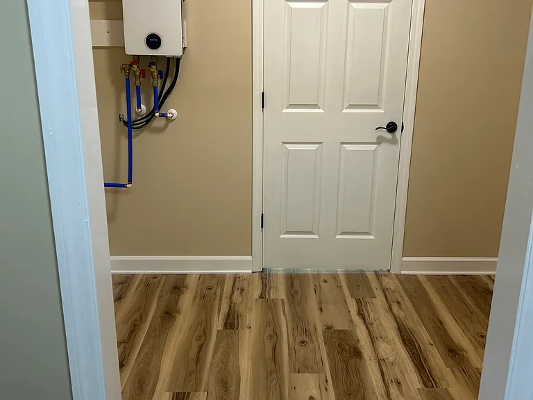 View from mud room. Spacious laundry area with electric tankless water heater providing electrical savings and endless supply of hot water.