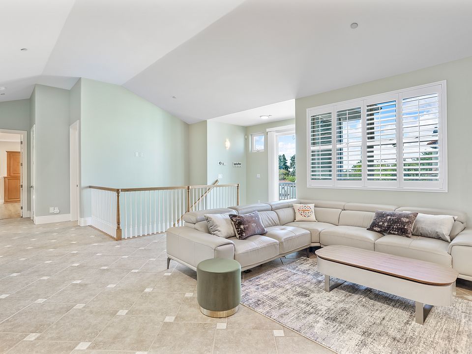 Family Room with Gray Leather Sectional - Coffee Table - Ottomans - Lighting - Area Rug