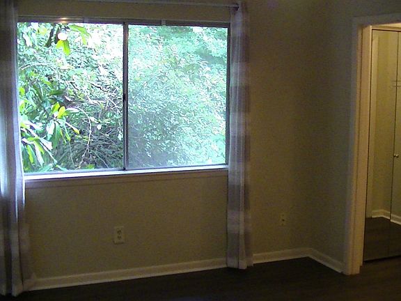 Master bedroom, with two double-wide closets (mirrored folding doors) leading into the bathroom (with tile floor, tub shower and curved curtain rod).