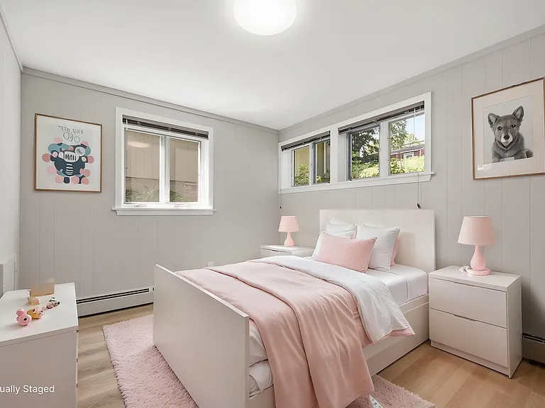 Primary bedroom with large south-facing window and gorgeous view of back-yard plants