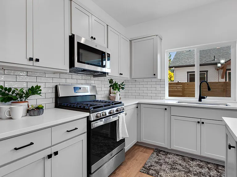 Modern kitchen featuring quartz countertops and stylish backsplace.