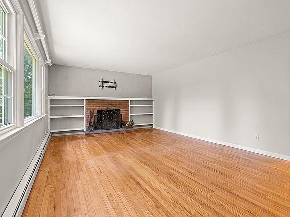 Living room with wood burning fireplace and built-ins.