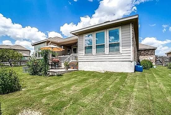 Landscaped backyard with covered porch and deck. Privacy fenced. Backs up to green space.